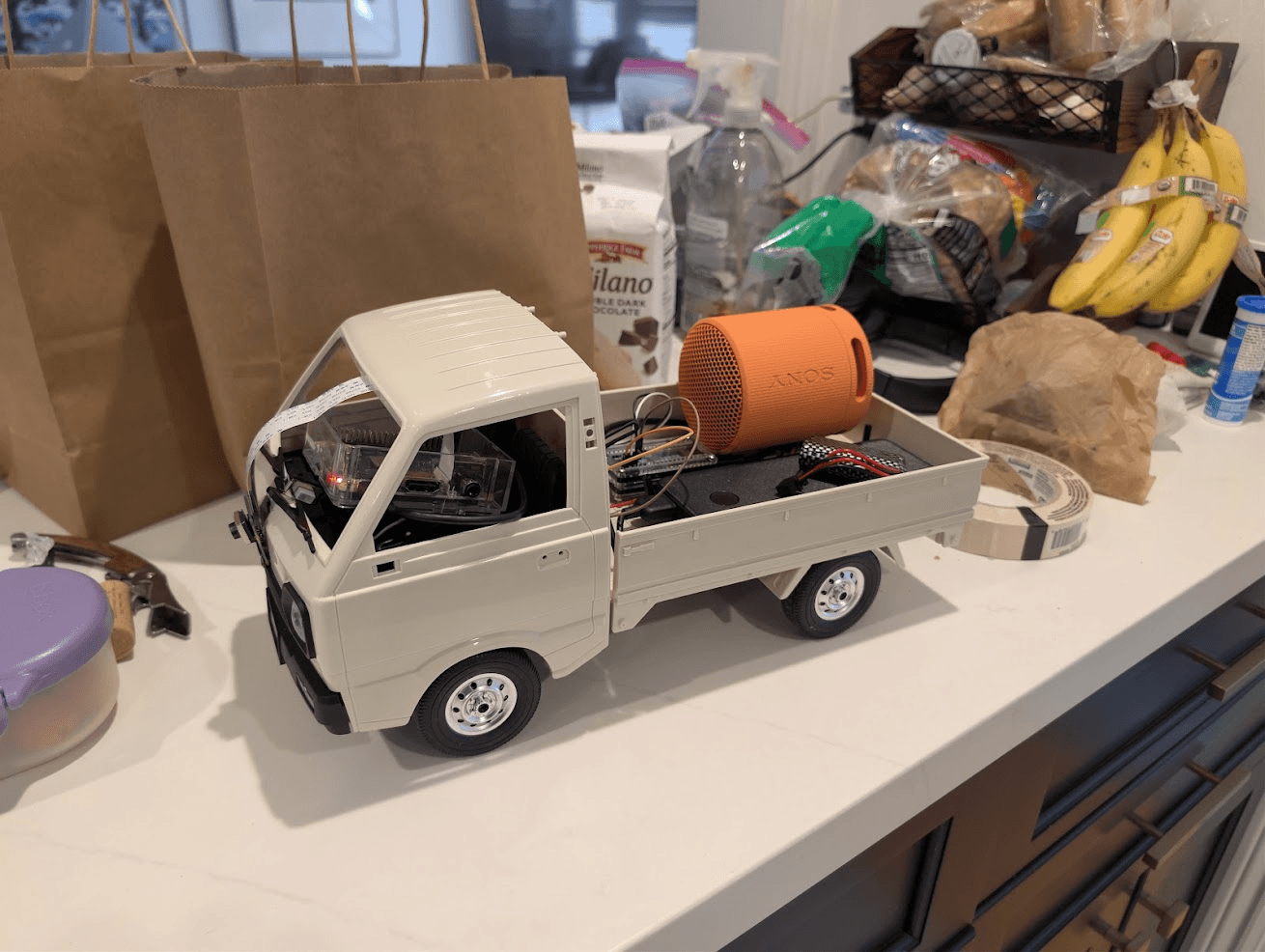 White Keitrain model truck with onboard electronics and an orange Sony speaker in its bed.